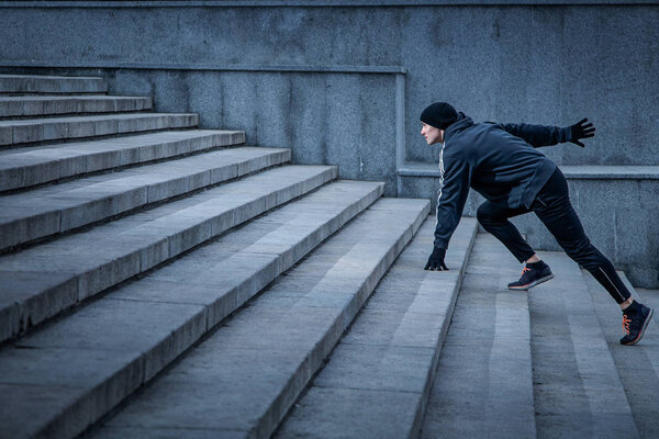 Athletic young man runs up the stairs.