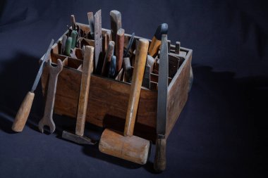 El ile karanlık bir arka plan üzerinde çalışmak için vintage araçları.