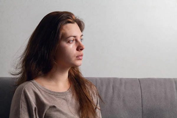 Genç kadın ağlıyor. Yanaklarının aşağı gözyaşları akışı.