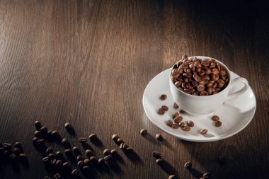 Doğal kavrulmuş kahve çekirdekleri ile dolu bir beyaz Kupası.