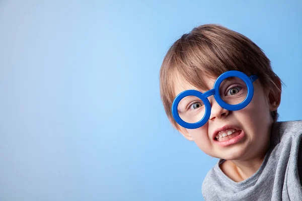 Stüdyo mavi zemin üzerine mavi gözlük şirin bebek.
