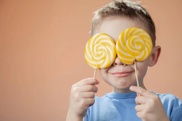 Vrolijke Knappe Jongen Met Twee Snoepjes Zijn Handen Kinder Vakantie — Stockfoto