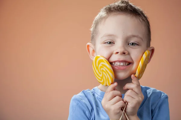 Mooie Schattige Jongen Met Gele Candy Een Lichte Achtergrond — Stockfoto