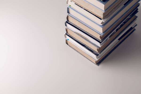 A stack of old and new books on a white-gray background.