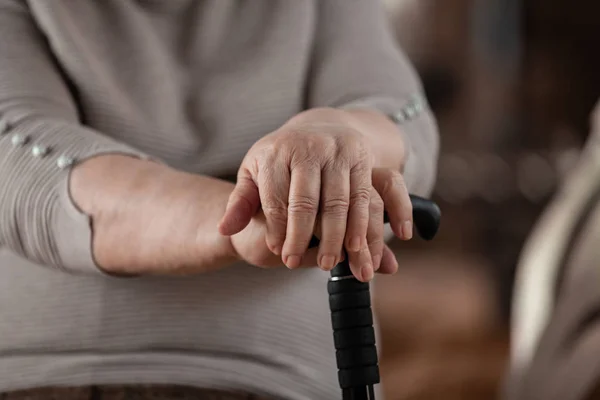 Female elderly hands hold a care wand. Retired woman.