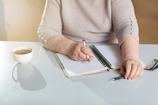A woman takes notes in a notebook in the office.