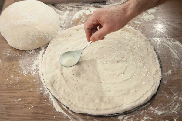 A man is cooking pizza. The cooking process.