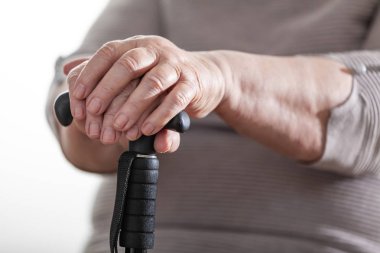 Emekli kadın, elleri ve baston yakın çekim.