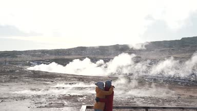 birkaç turist geysers arka plan üzerinde kucaklamak