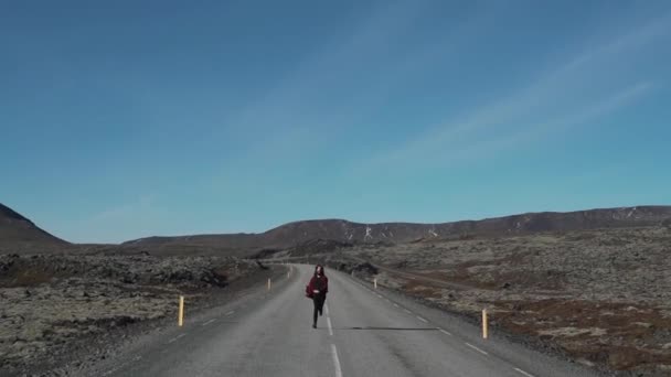 Dívka je spuštěn po prázdné silnici na Islandu — Stock video
