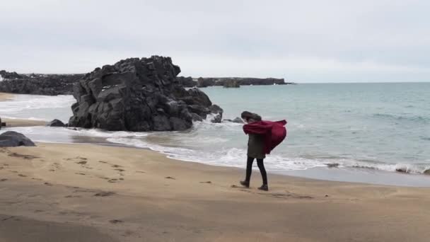 Una chica camina cerca del océano en clima frío — Vídeos de Stock