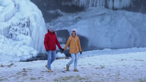 Een paar toeristen lopen rond de gletsjer — Stockvideo