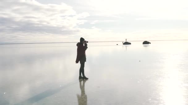 Turist flicka tar ett foto av frusen sjö — Stockvideo