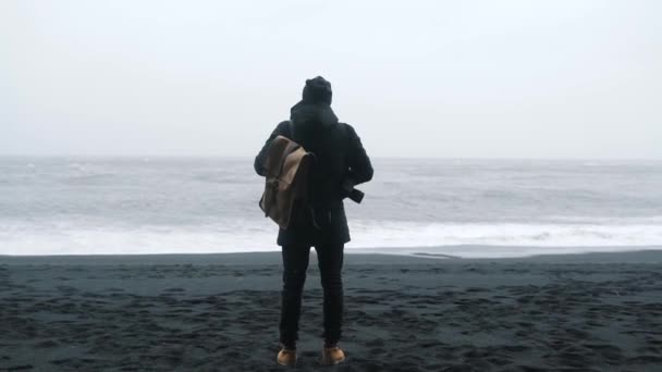 Ταξίδια άνδρα με σακίδιο κοντά στο θυελλώδη ωκεανό — Αρχείο Βίντεο