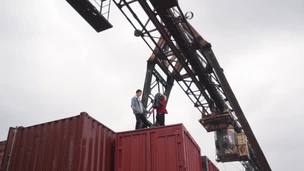 Giovane coppia a piedi su un container merci — Video Stock