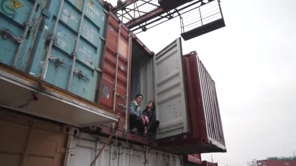 Jong koppel zit in de vrachtcontainer — Stockvideo