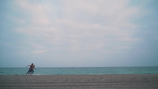 Par i denim promenad på stranden — Stockvideo