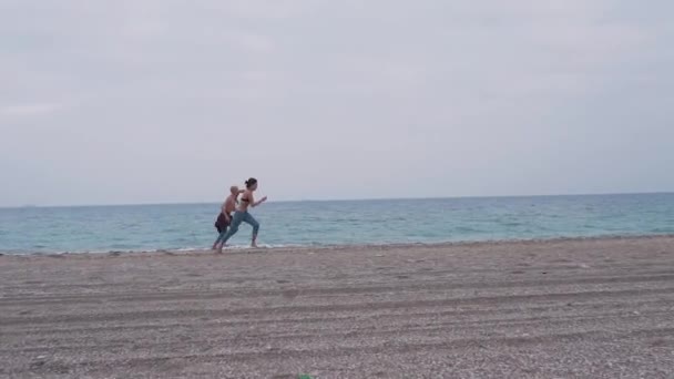 若いカップルがビーチで実行します。 — ストック動画