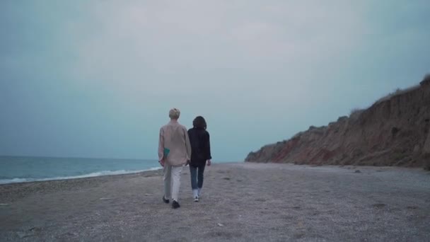 Мужчина следует за девушкой на пляже — стоковое видео