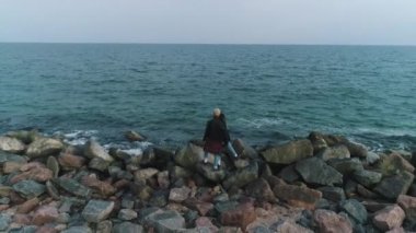 taşlı bir plajda denize yakın çift