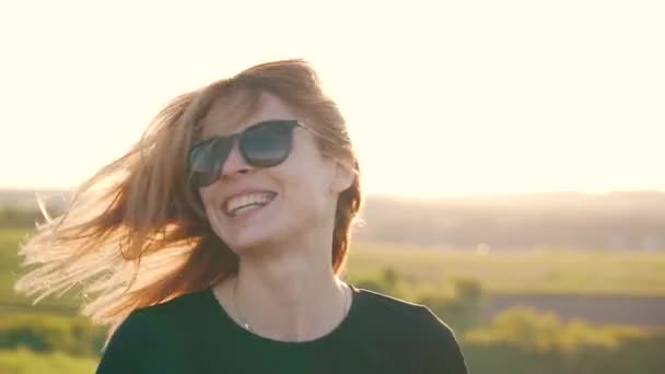 Chica feliz sacude la cabeza y el pelo al aire libre — Vídeo de stock