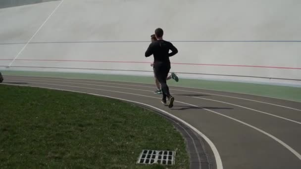 Mężczyźni biegną wzdłuż bieżni na stadionie — Wideo stockowe
