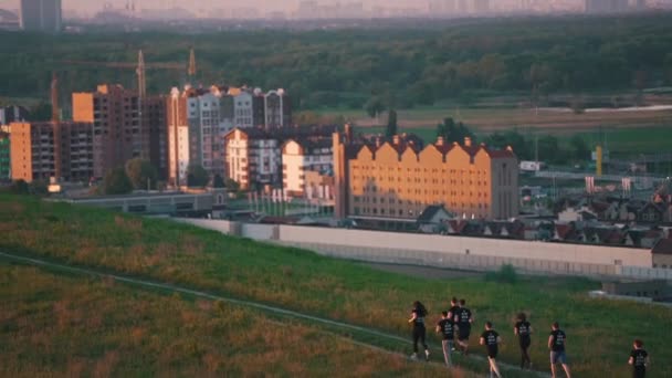 Группа людей, бегущих на фоне города — стоковое видео