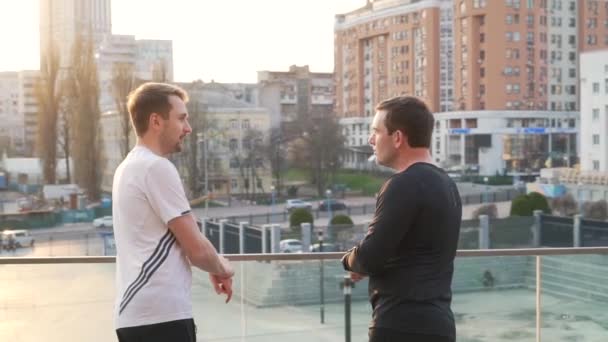 Hommes en vêtements de sport après le jogging dans la ville — Video