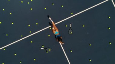 Tenis kortunda oynak kız yatıyor