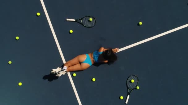 A lány fekszik a hasán a teniszpályán — Stock videók