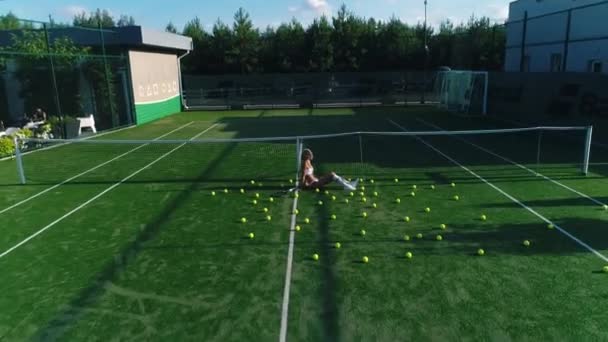 Menina loira em um campo de ténis — Vídeo de Stock