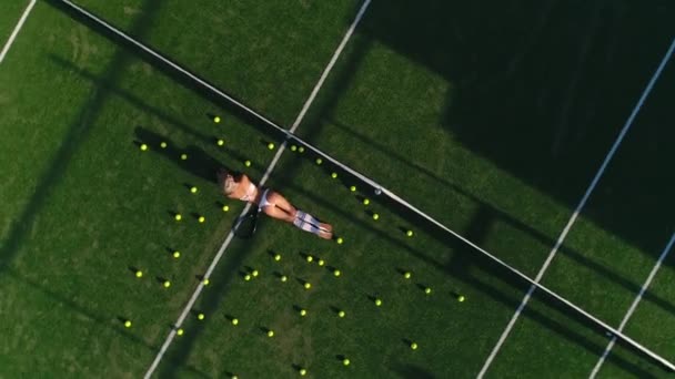 Modelo chica se encuentra en una pista de tenis — Vídeo de stock