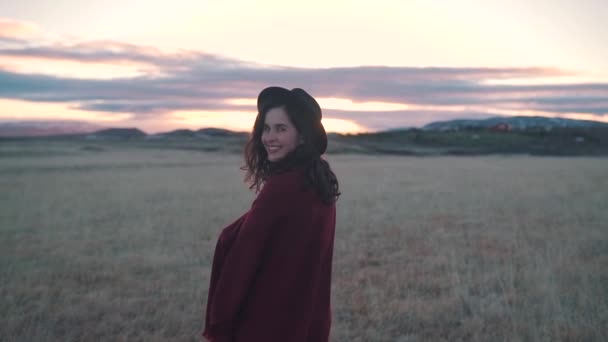 Menina feliz caminha no campo ao pôr do sol — Vídeo de Stock