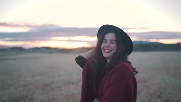 Šťastná dívka úsměvy v poli při západu slunce — Stock video