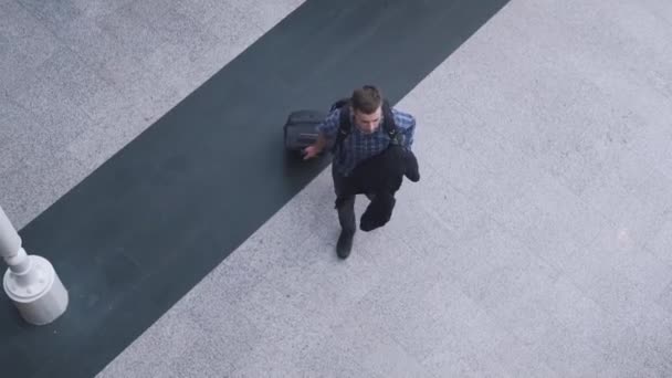 Чоловік приходить з видом зверху валізи — стокове відео