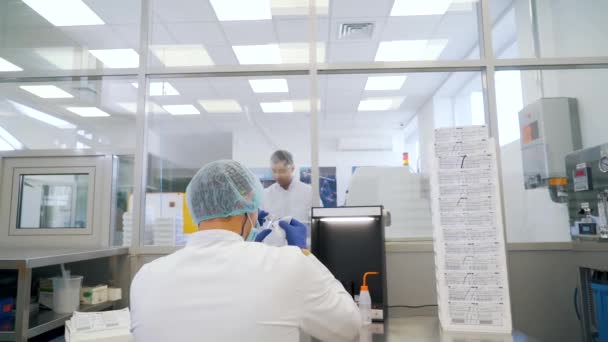 Homme frotte la lentille en laboratoire vue arrière — Video