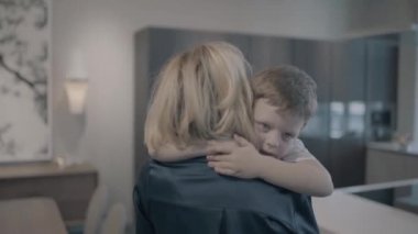 Anne oğlunu kollarındaki ve hugs taşır