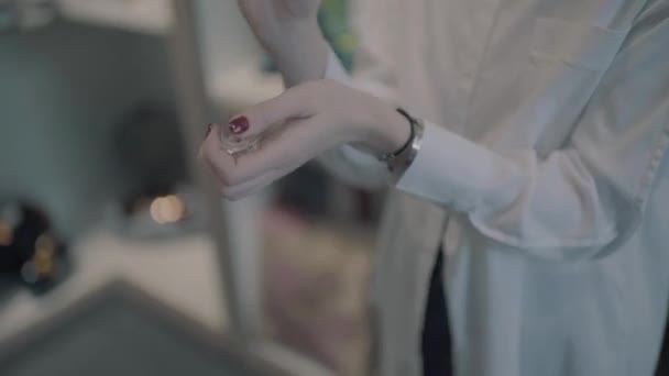 Flicka sätter parfym på sin handled — Stockvideo
