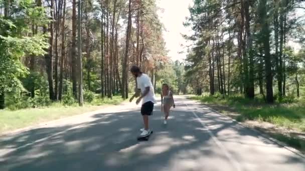 Paar plezier maken met het schaatsen op een lege weg — Stockvideo