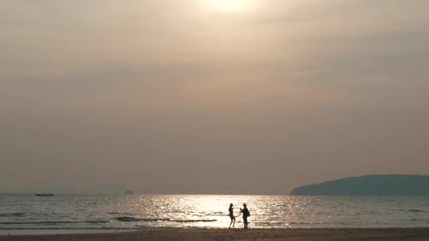 Couple au bord de l'océan au coucher du soleil — Video