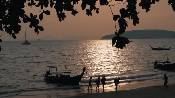 Personnes et bateaux au coucher du soleil — Video