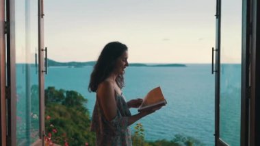 okyanus arka planda bir kitap ile yapraklı kız