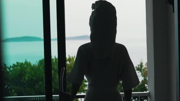 Дівчина в халаті з видом на океан — стокове відео