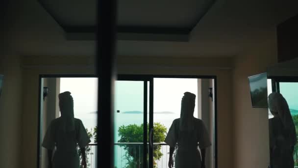 Mädchen geht auf den Balkon mit Blick auf das Meer — Stockvideo