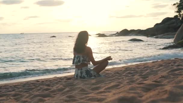 Kız okyanus tarafından kum üzerinde oturan meditasyon — Stok video