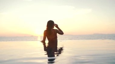 gün batımında okyanusun arka planda havuzda kız