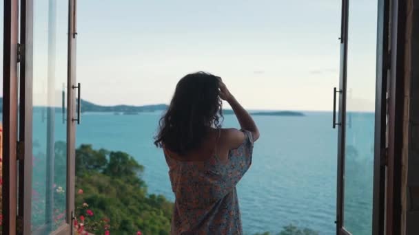 Menina em um apartamento com vista para o oceano — Vídeo de Stock