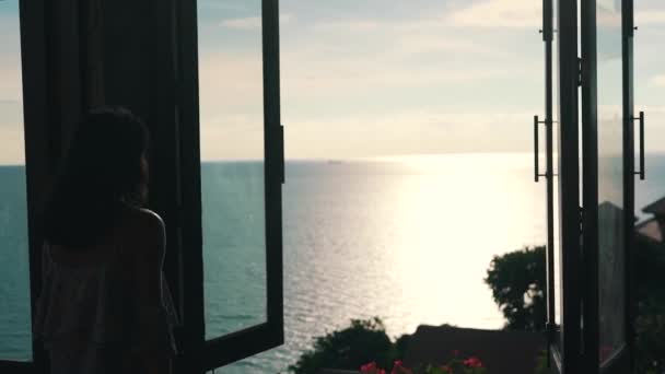 Дівчина в квартирі з видом на океан — стокове відео