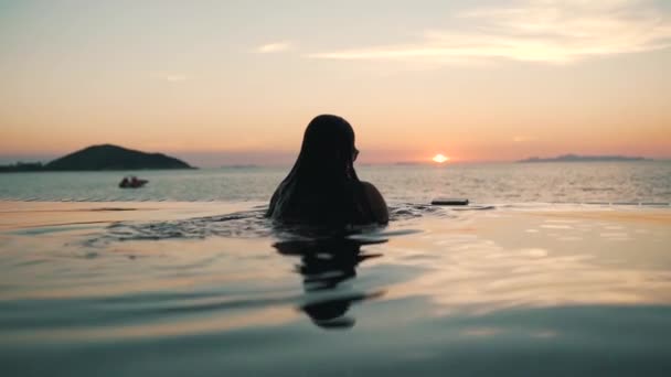 A menina chills para fora na piscina no por do sol — Vídeo de Stock