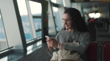 kız havaalanı salonunda akıllı telefon kullanır